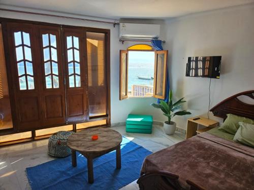 a bedroom with a bed and a table and a window at Sirena Dahab in Dahab