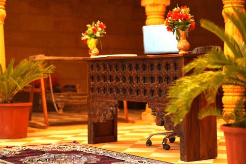 a desk with a laptop on it with flowers on it at The Desert Gateway Resort in Jaisalmer