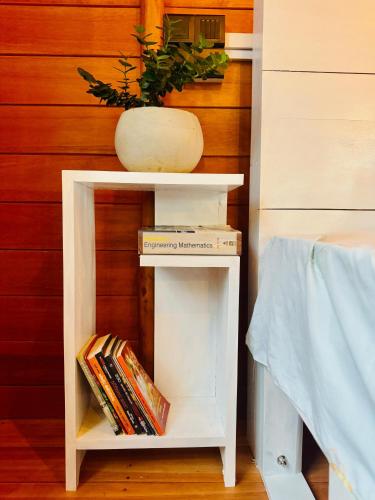 a book shelf with a potted plant and books at Fisherman's Hut in Habaraduwa