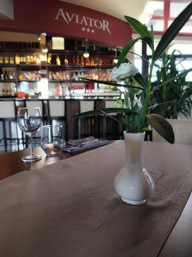 a vase with flowers on a table in a restaurant at Aviator Hotel Restauracja & SPA in Pabianice