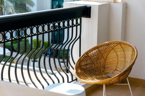 a wicker chair sitting next to a fence at Glamorous Modern 2BHK in Yas Island 324 in Abu Dhabi