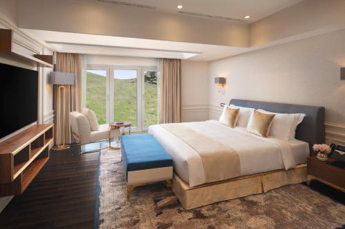 a hotel room with a large bed and a television at Ayan Zalaat in Ulaanbaatar
