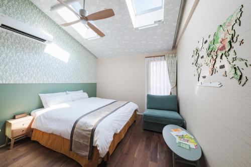 a bedroom with a bed and a blue chair at GOOD DAY Shinagawa HOTEL in Tokyo