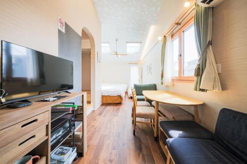 a living room with a couch and a tv and a table at GOOD DAY Shinagawa HOTEL in Tokyo