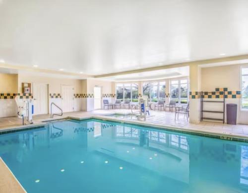 a swimming pool with blue water in a building at Hilton Garden Inn Wichita Airport in Wichita