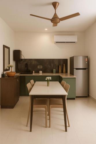 a kitchen with a table with chairs and a refrigerator at Swagatha The Beach House 3Bhk Villa in Tirupporūr