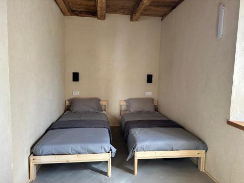 two beds sitting in a room with a wall at La finestra sul grappa in Seren del Grappa