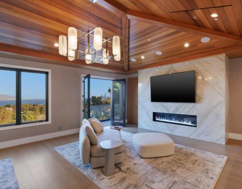 a living room with a fireplace and a tv at Dume Malibu in Malibu