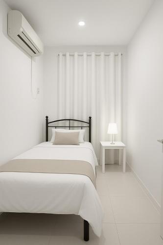 a white bedroom with a bed and a side table at Private luxury stay Abudhabi - Check out 2 pm in Abu Dhabi