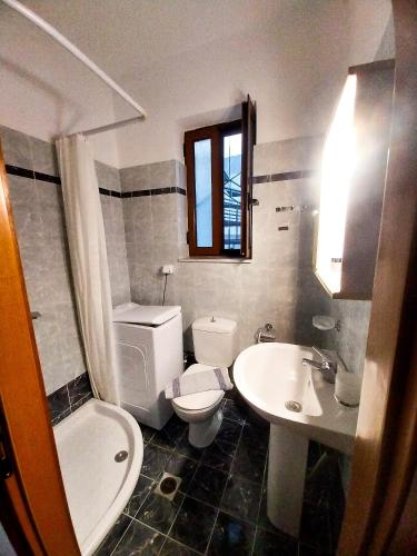 a bathroom with a white toilet and a sink at Malvazios Villas #2 in Gythio