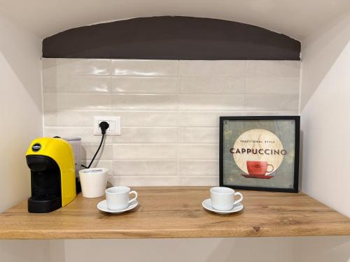 a shelf with cups and a coffee maker on it at Casa Arlotta Portici 20 in Portici