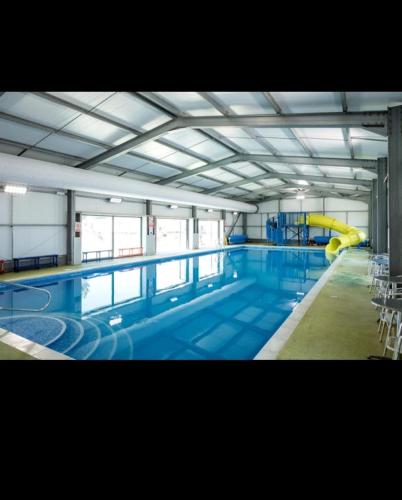a large indoor swimming pool with a pool slide at J & C caravans in Saint Osyth