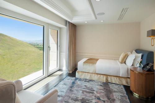 a hotel room with a bed and a large window at Ayan Zalaat in Ulaanbaatar