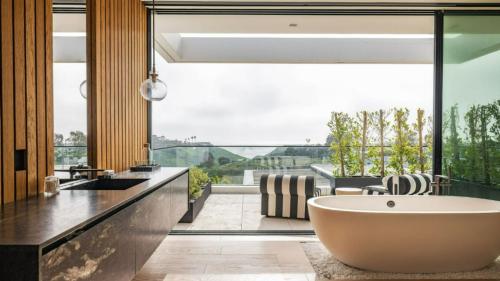 a bathroom with a tub and a large window at The Dume Legacy in Malibu