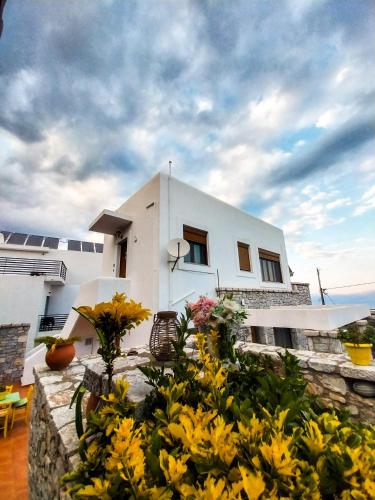 a white house with yellow flowers in front of it at Malvazios Villas #2 in Gythio