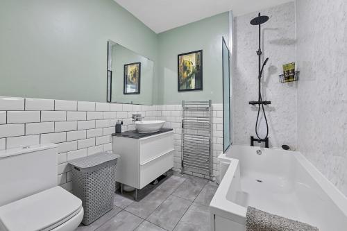 a bathroom with a sink and a toilet and a tub at Arundel House - Parkview with free parking in Plymouth