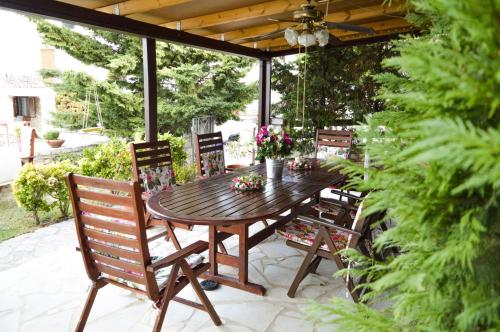 a wooden table and chairs on a patio at Malvazios Villas #2 in Gythio