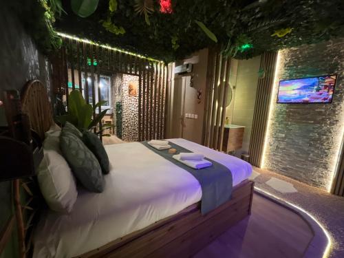 a bedroom with a large bed with lights on it at Jungle Room Jacuzzi Ambiance Tropicale in Épernay