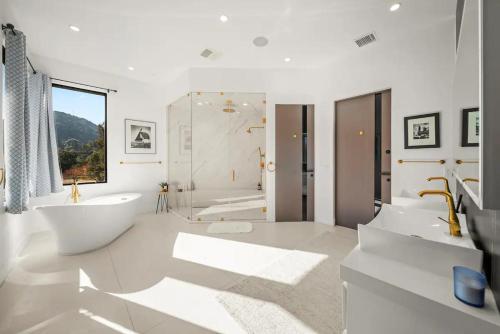Un baño blanco con bañera y lavabo. en Willow Glen, en Los Ángeles