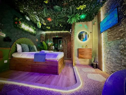 a bedroom with a bed in a room with plants at Jungle Room Jacuzzi Ambiance Tropicale in Épernay