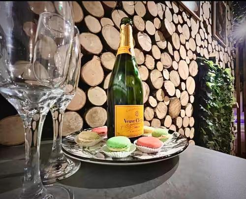 a bottle of champagne and a plate of cupcakes at Jungle Room Jacuzzi Ambiance Tropicale in Épernay
