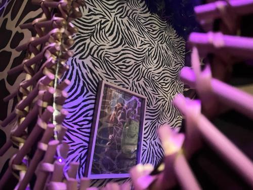 a picture on a wall with a zebra pattern at Jungle Room Jacuzzi Ambiance Tropicale in Épernay