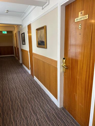 a hallway of a hotel with a door with a sign on it at Westone Manor Hotel in Northampton