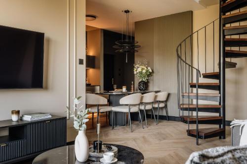 a living room with a staircase and a table with chairs at Azure Palace - LoftAffair Collection in Kraków