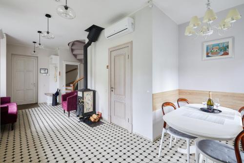 a white dining room with a table and chairs at Lettia Aparthotel in Jūrmala