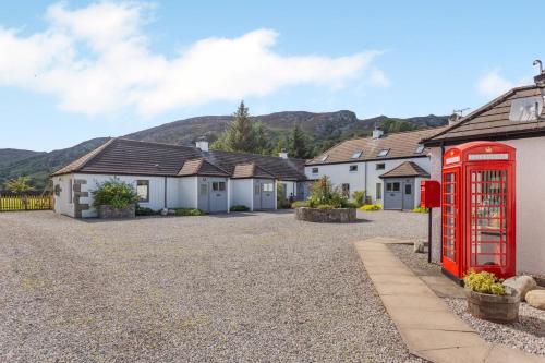 a red phone booth in front of a row of houses at 1 Bed in Newtonmore oc-a32412 in Newtonmore