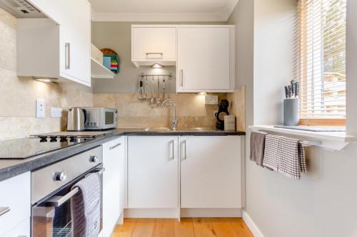 a kitchen with white cabinets and a sink at 1 Bed in Newtonmore oc-a32412 in Newtonmore