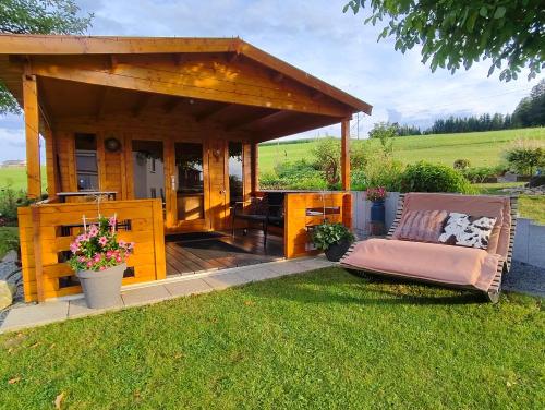a gazebo with a couch and chairs in the grass at Ferienhof Schaubmeier in Klaffer am Hochficht