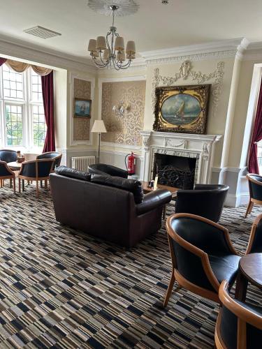 a living room with a couch and a fireplace at Westone Manor Hotel in Northampton
