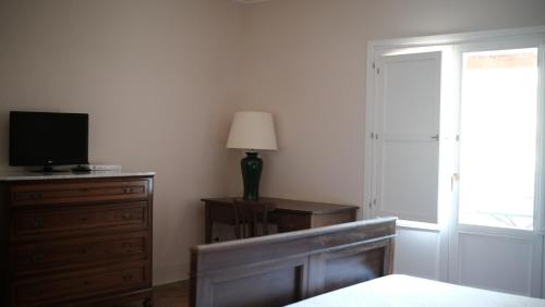 a bedroom with a bed and a dresser with a television at Relais Masseria Cardillo in Metaponto
