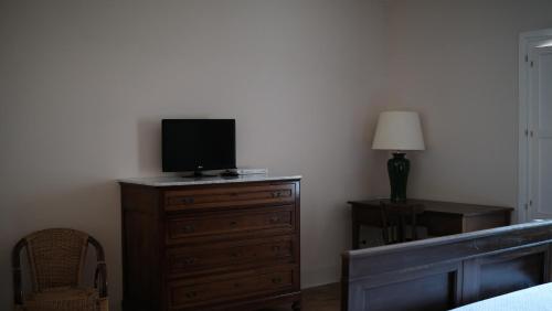 a bedroom with a dresser with a television on it at Relais Masseria Cardillo in Metaponto