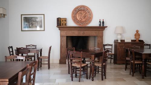 a dining room with a fireplace and tables and chairs at Relais Masseria Cardillo in Metaponto