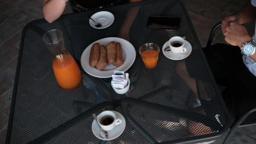 a table with a plate of breakfast foods and orange juice at Relais Masseria Cardillo in Metaponto