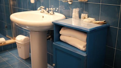 a blue bathroom with a sink and a white sink at Relais Masseria Cardillo in Metaponto