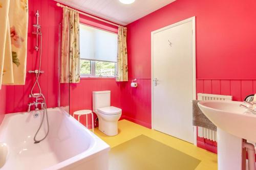 a bathroom with a tub and a toilet and a sink at The Gatehouse - Kettlestone in Little Snoring