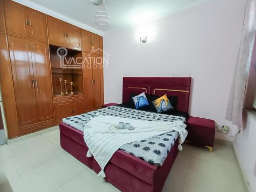 a bedroom with a large bed and wooden cabinets at BnBBuddy 2 BR Anugraha, Dwarka in New Delhi