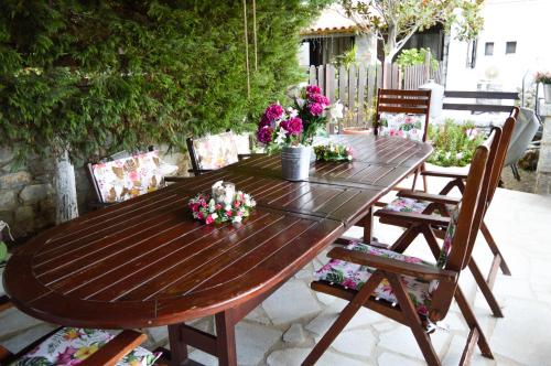 a wooden table with flowers on a patio at Malvazios Villas #2 in Gythio