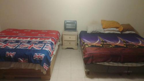 ein Schlafzimmer mit zwei Betten und einer Kommode mit Fernseher in der Unterkunft Alojamiento OLSI in Torreón