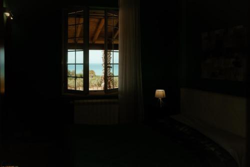 a window in a dark room with a lamp at Villa Mancosta in Marinella di Selinunte