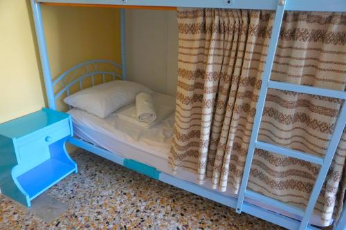 a bedroom with a bunk bed with a ladder at Chrissi Ammos in Perissa
