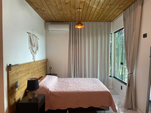a bedroom with a bed and a window at The Private Forest Lake Tinys Aruanda in Mata de Sao Joao