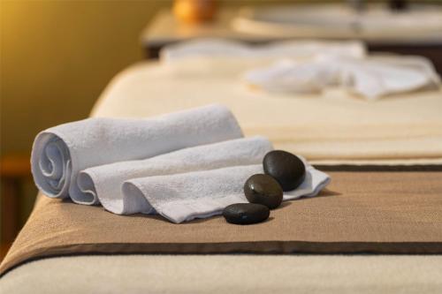two beds with towels and stones on a table at Occidental Boa Vista Beach in Rabil
