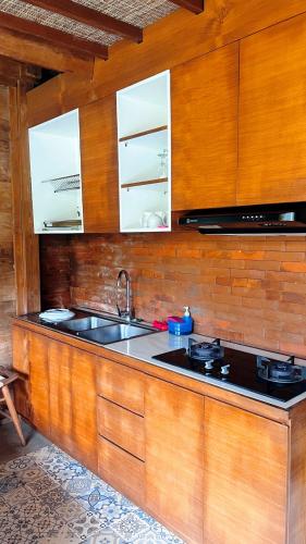 a kitchen with wooden cabinets and a sink at Private 2 Bedroom Villa by Nami Bali in Meliling