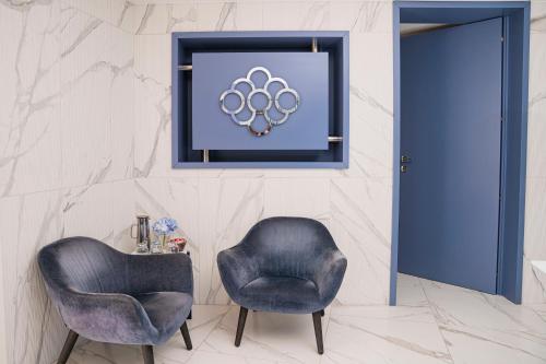 a room with two chairs and a picture of the olympics at Villa Gervasio Rooms in Bacoli