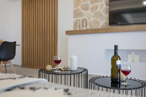 a table with a bottle of wine and two glasses at BLUE SEA Naxos in Stelida