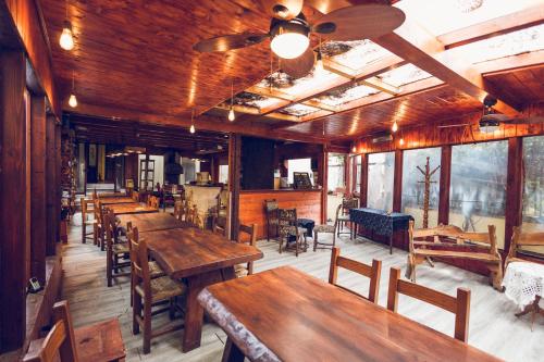 a restaurant with wooden tables and chairs and windows at Fermati che è tardi in Tivoli